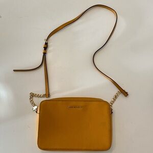 Perfect size Michael Kors mustard yellow crossbody bag with gold chain strap.
